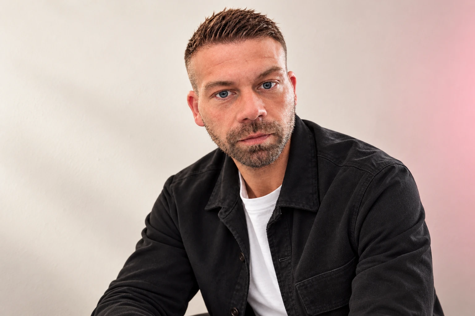 Niko Ruzicka, Ansprechpartner bei ZANOQ, vor einem warmen cremefarbenen Hintergrund.