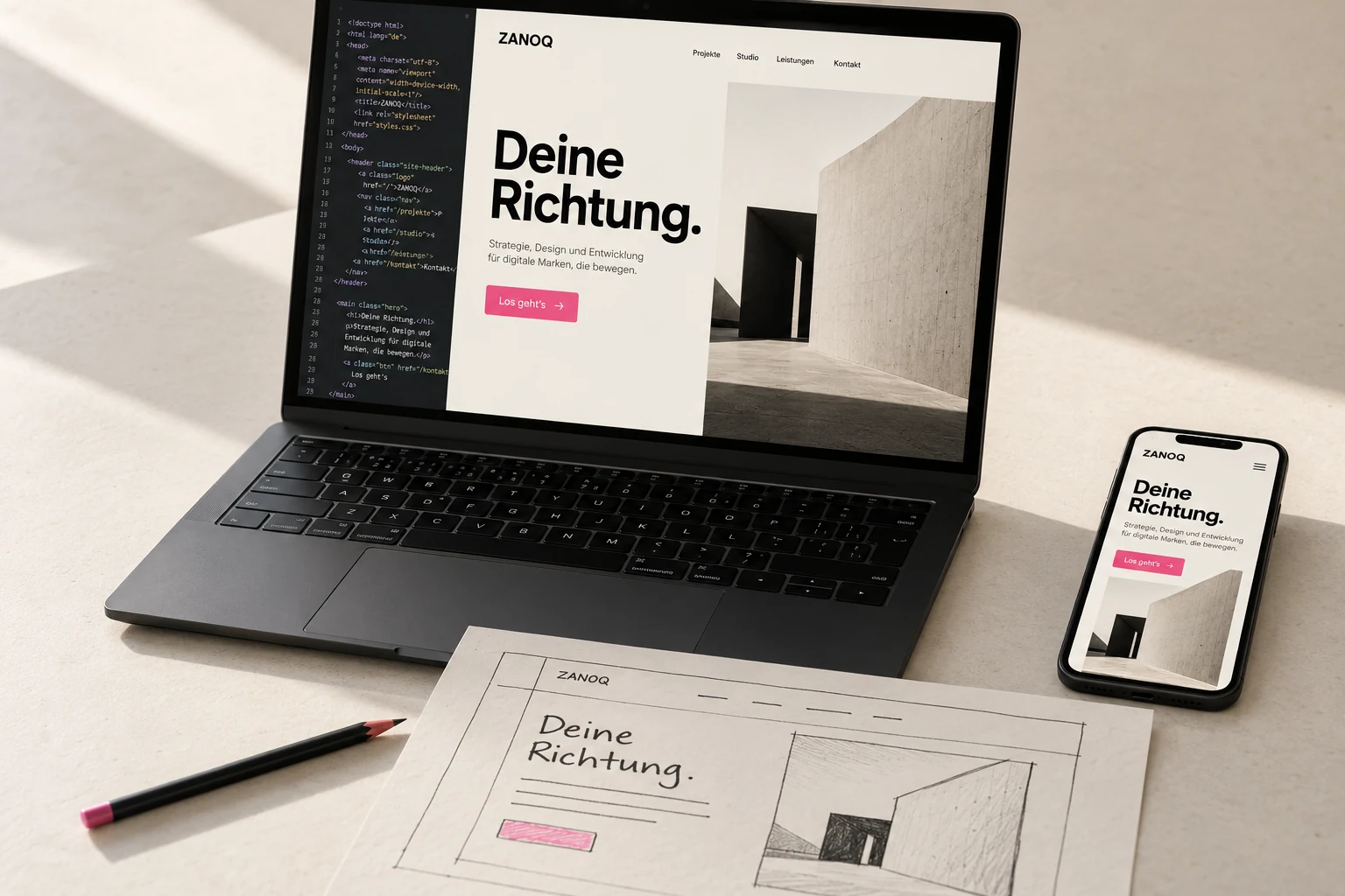 Website in der Entwicklung auf Laptop und Smartphone neben dem Papierentwurf.